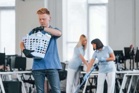 woman uses vacuum cleaner inside a classroom